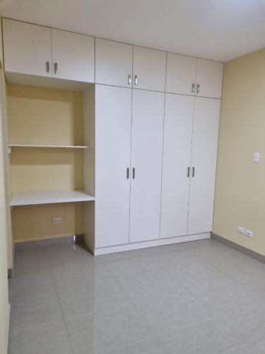 an empty room with white cabinets and a tile floor at Habitación para Estudiantes in Lima