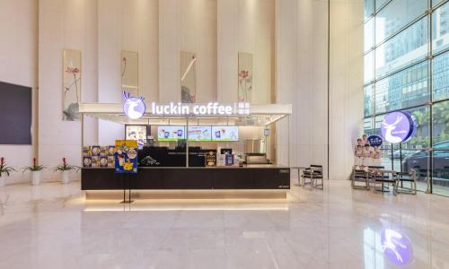 a lobby of a mall with a coffee shop in it at Real Joy Light in Shenzhen