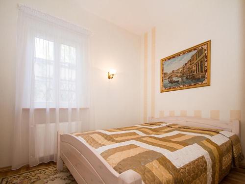 1 dormitorio con 1 cama y una pintura en la pared en Aparte Lux, en Jūrmala