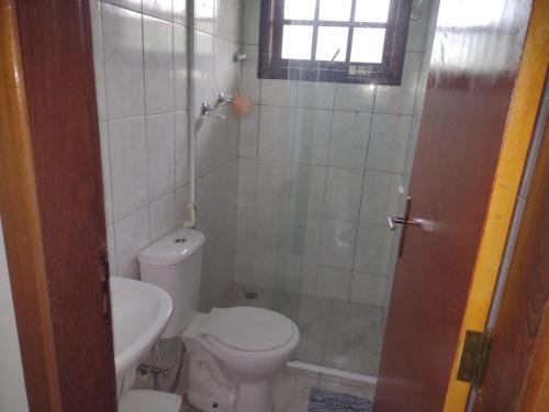 a bathroom with a toilet and a shower at Casa Caraguá in Caraguatatuba