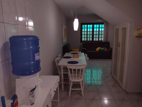 a kitchen with a table with a blue bucket on it at Casa Caraguá in Caraguatatuba