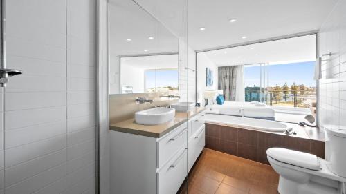 a bathroom with a sink and a toilet and a tub at Bayview 608 in Mandurah