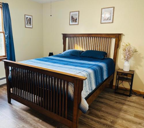 a bedroom with a wooden bed with a blue comforter at Spacious Country Home, Hot Tub, Fire Pit, Deck 