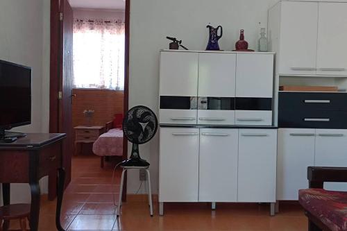 - un salon avec des armoires blanches et un ventilateur dans l'établissement Casa de praia Pitória São Pedro da Aldeia, à São Pedro da Aldeia