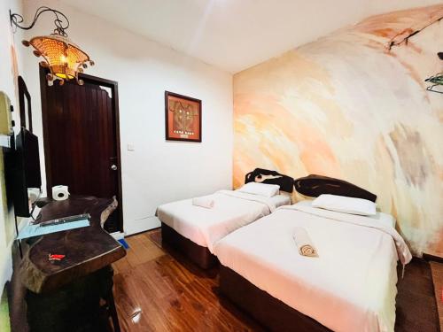 a hotel room with two beds and a television at Kuching Waterfront Lodge in Kuching