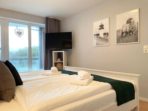 a bedroom with a large bed with towels on it at Haus Nordseebrandung FeWo C2 2 in Cuxhaven