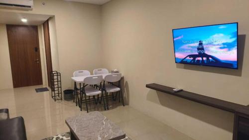 a waiting room with chairs and a tv on the wall at SleepRest @ NTC in Nagoya