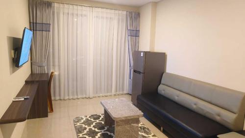 a living room with a couch and a television at SleepRest @ NTC in Nagoya