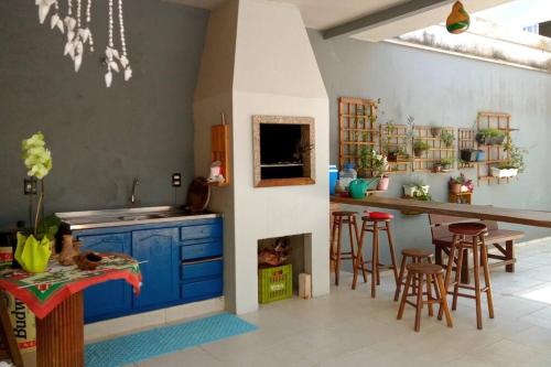 uma cozinha com armários azuis e um balcão com bancos em Casa em Balneário Camboriú em Balneário Camboriú
