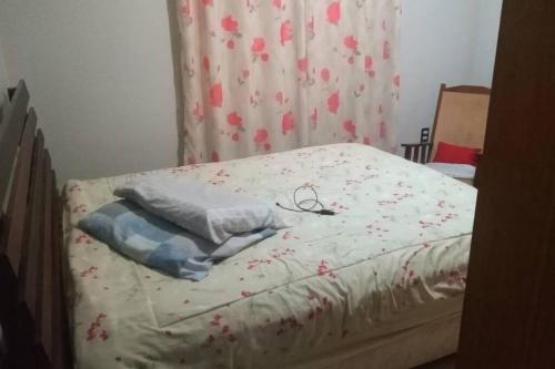 uma cama não feita com flores num quarto em Casa em Balneário Camboriú em Balneário Camboriú