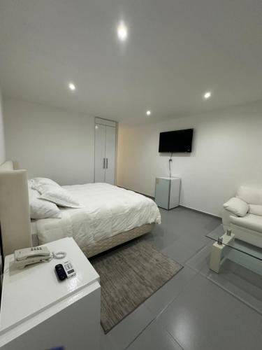 een slaapkamer met een bed en een flatscreen-tv bij Cantares Adults Only in Cancun