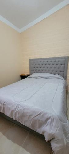 łóżko w sypialni z białą narzutą w obiekcie Departamentos Borges w mieście Santiago del Estero