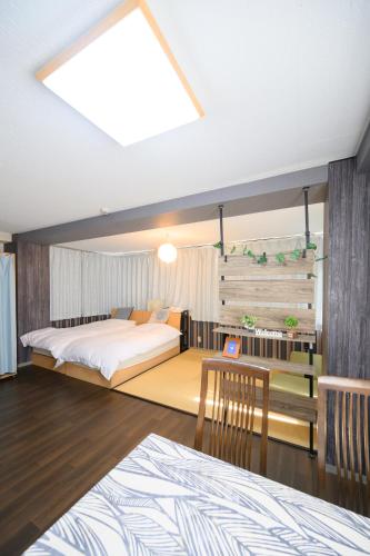 a bedroom with a large bed and a table at Yiyihouse shinsaibashi in Osaka