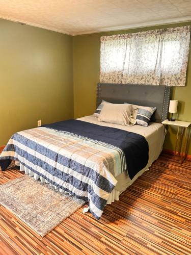 a bedroom with a bed with a blue and white blanket at Cozy Apartments In Cheektowaga in Cheektowaga