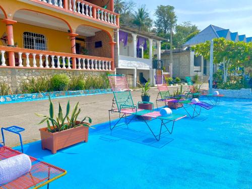 una piscina con sillas y plantas frente a una casa en Hotel San Miguel en Flores