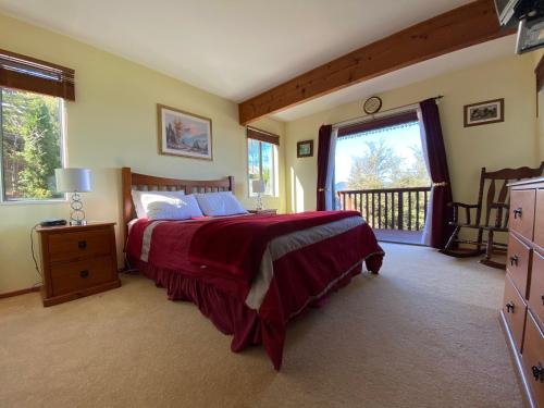a bedroom with a large bed and a balcony at 16 Oregon Heights in Hanmer Springs