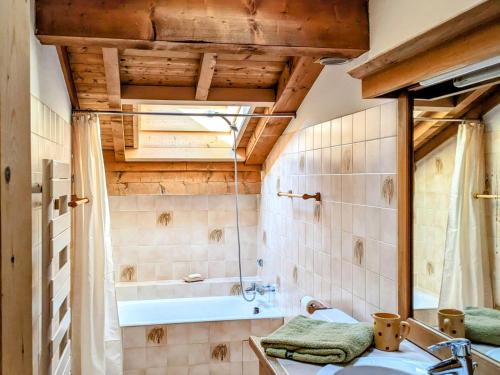 ein Badezimmer mit einer Badewanne und einem Waschbecken in der Unterkunft Chalet Combloux, 6 pièces, 10 personnes - FR-1-560-88 in Combloux