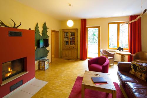 a living room with a couch and a fireplace at Plumbohms ECHT-HARZ-HOTEL in Bad Harzburg