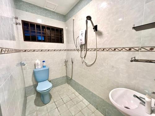 a bathroom with a blue toilet and a sink at Pleasant Stay @ Sunway (16-20 pax ) 5 min to Lost World of Tambun in Tambun