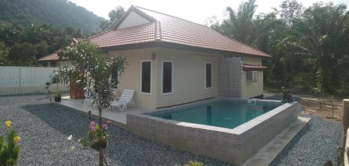 a small house with a swimming pool in front of it at Villa Cattleya in Ko Lanta