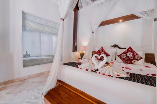 1 dormitorio con 2 camas y almohadas rojas y blancas en Alam Bidadari Seminyak, en Seminyak
