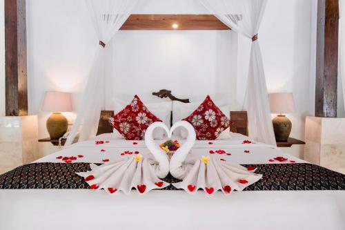 una cama con dos cisnes hechos de flores en Alam Bidadari Seminyak, en Seminyak
