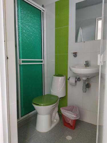 a bathroom with a green toilet and a sink at Cabañas Chavita PISO 1 Coveñas in Coveñas