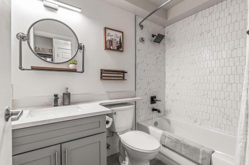 a bathroom with a sink and a toilet and a mirror at NEW! Central Canmore- Light Industrial Hotel Room in Canmore