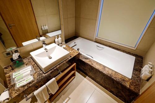 a bathroom with a sink and a bath tub at Holiday Inn Chennai OMR IT Expressway by IHG in Chennai
