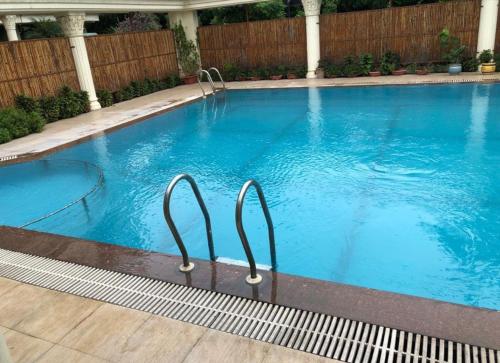 una gran piscina de agua azul en un patio en Sangam Resort, pilani, en Chirāwa