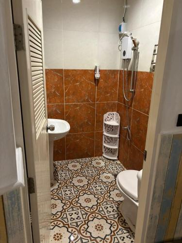a bathroom with a toilet and a sink at La Locanda in Bangkok
