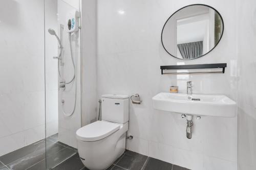 a bathroom with a toilet and a sink and a mirror at Nowhere 2BR & 2Bath Apartment with Balcony @ Reizz Residences in Kuala Lumpur