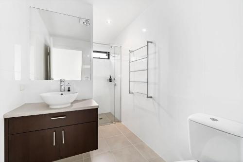 a white bathroom with a sink and a shower at Earth Sea Sky in Wye River