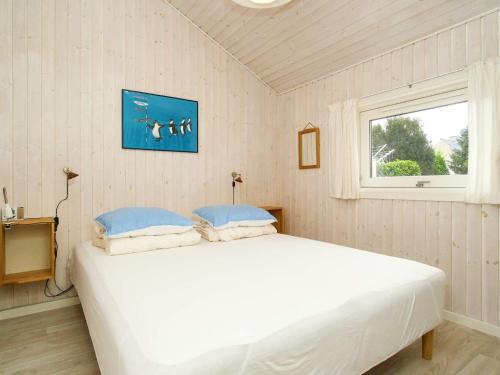 Cama blanca en habitación con ventana en Holiday home Ølsted IV, en Ølsted