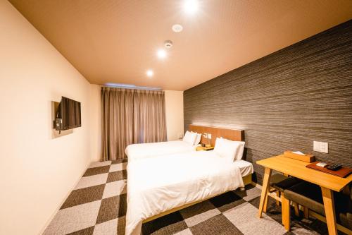 a hotel room with two beds and a table at HOTEL THE POINT Kiyomizu Gojo in Kyoto