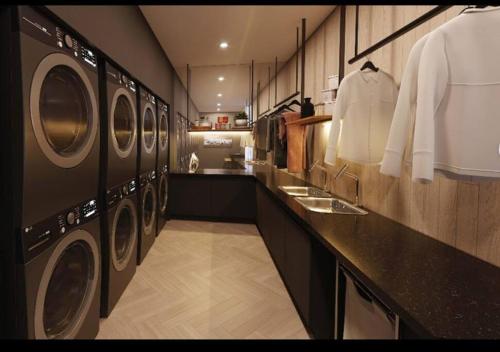 - une buanderie avec 3 lave-linge et un comptoir dans l'établissement Hermoso y cómodo ApartmentStudio, à Quito