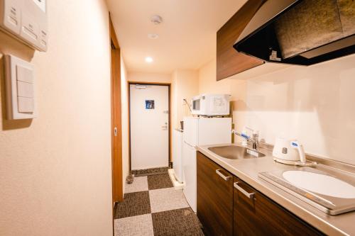 a small kitchen with a sink and a refrigerator at HOTEL THE POINT Kiyomizu Gojo in Kyoto
