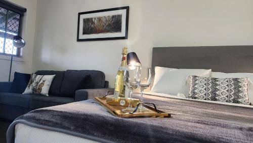 a bedroom with a bed with a couch and a table at Alpine Village Jindabyne in Jindabyne