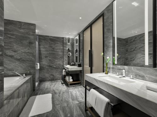 a bathroom with two sinks and a large mirror at DoubleTree by Hilton Chengdu Riverside - Close to Panda Base and Chengdu East Railway in Chengdu