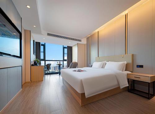 sypialnia z dużym białym łóżkiem i telewizorem w obiekcie Zhangjiajie Hero Boutique Hotel w mieście Zhangjiajie