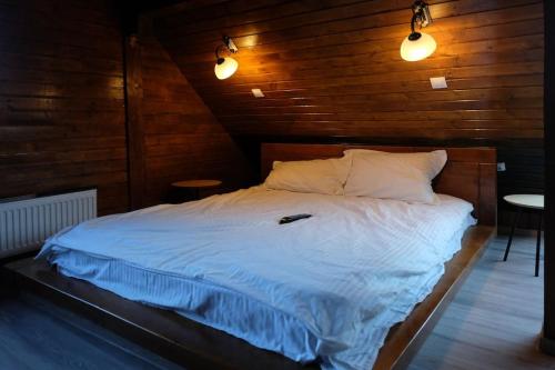 een slaapkamer met een bed met witte lakens en 2 verlichting bij La Piscina di Diutz - No smoking in Cîrcea