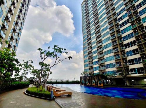 une rivière avec bancs devant de grands bâtiments dans l'établissement GREEN SEDAYU APARTMENT b28, à Jakarta