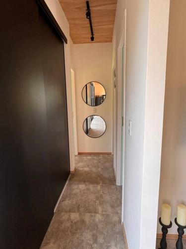 a hallway with a door and a mirror on the wall at Nandina, en el bosque y playa in La Pedrera