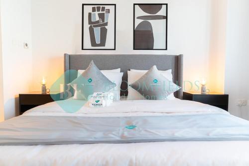 a bedroom with a white bed with blue pillows at Classic Studio In Water's Edge in Abu Dhabi