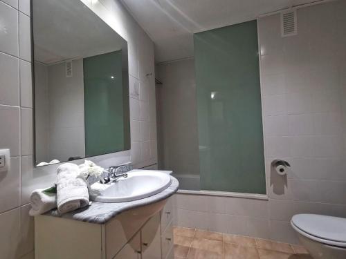 a bathroom with a sink and a mirror and a toilet at Apartamento en el Centro de Platja d'Aro con Piscina, Terraza y Cerca de la Playa - ES-209-45 in Platja  d'Aro