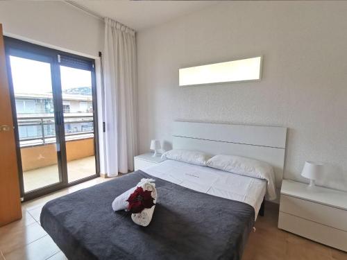 a bedroom with two beds and a large window at Apartamento en el Centro de Platja d'Aro con Piscina, Terraza y Cerca de la Playa - ES-209-45 in Platja  d'Aro