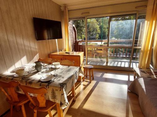une pièce avec une table et des chaises et une grande fenêtre dans l'établissement Studio cosy aux Deux Alpes - 4 pers, 32m², pied des pistes, balcon sud - FR-1-516-209, à Les Deux Alpes
