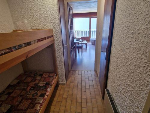 un couloir menant à une chambre avec un lit et une table dans l'établissement Studio 4 pers. pied des pistes, balcon sud, parking couvert - Les Deux Alpes - FR-1-516-208, à Les Deux Alpes