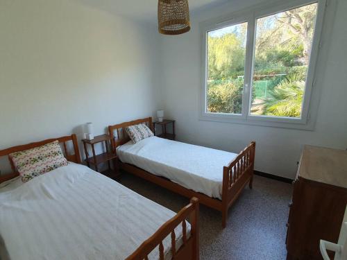 une chambre avec deux lits et une fenêtre dans l'établissement Maison Rénovée avec Jardin, Proche Plages des Issambres, Clim & Internet, Animaux Acceptés - FR-1-768-2, aux Issambres
