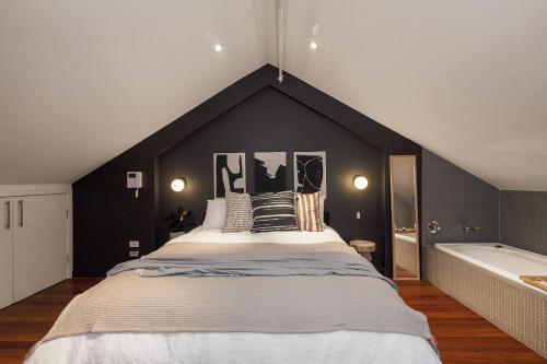 a bedroom with a large bed and a bath tub at Warburton's Loft in Melbourne